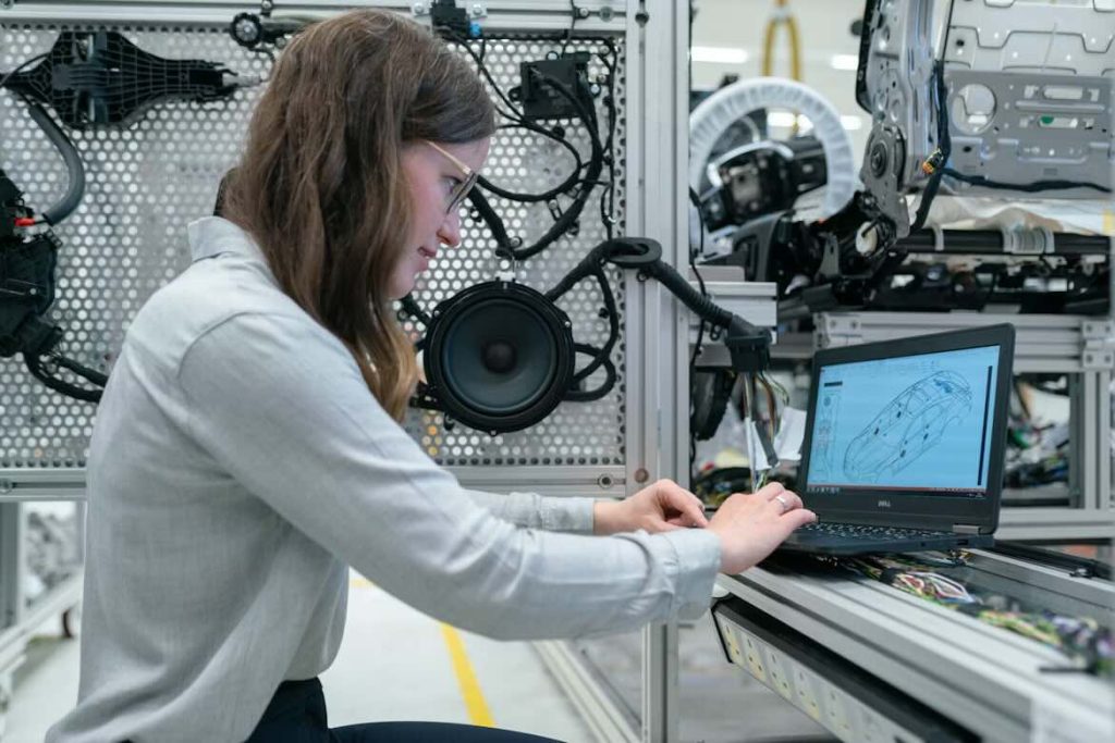 Woman with glasses engineering a car on her laptop