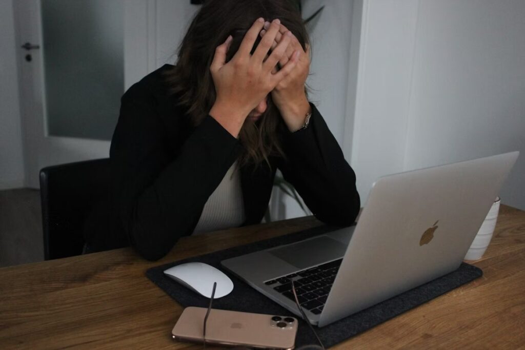 Person looking distressed over a laptop