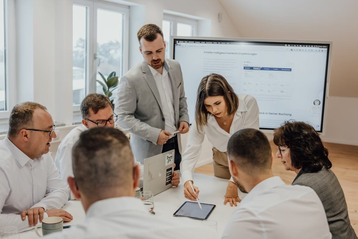 A group of professionals having a meeting with a screen behind them