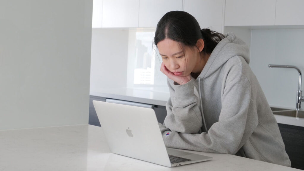 A person looking disinterested at a computer