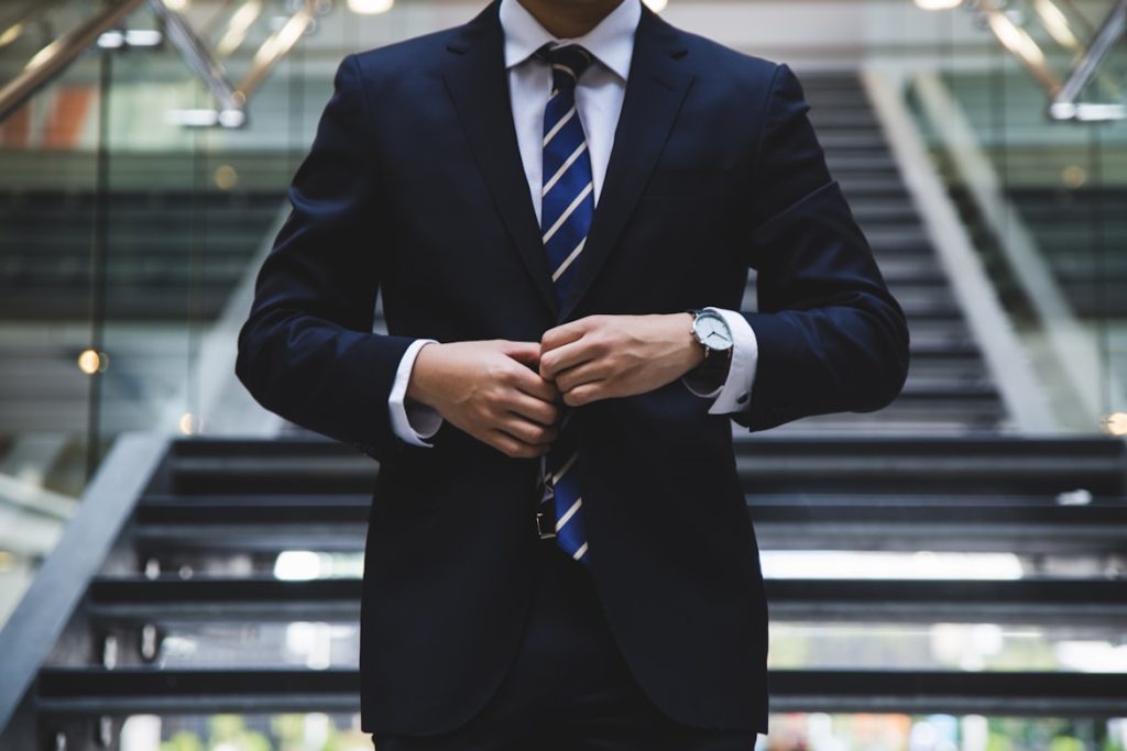 A professional looking person buttoning up a suit